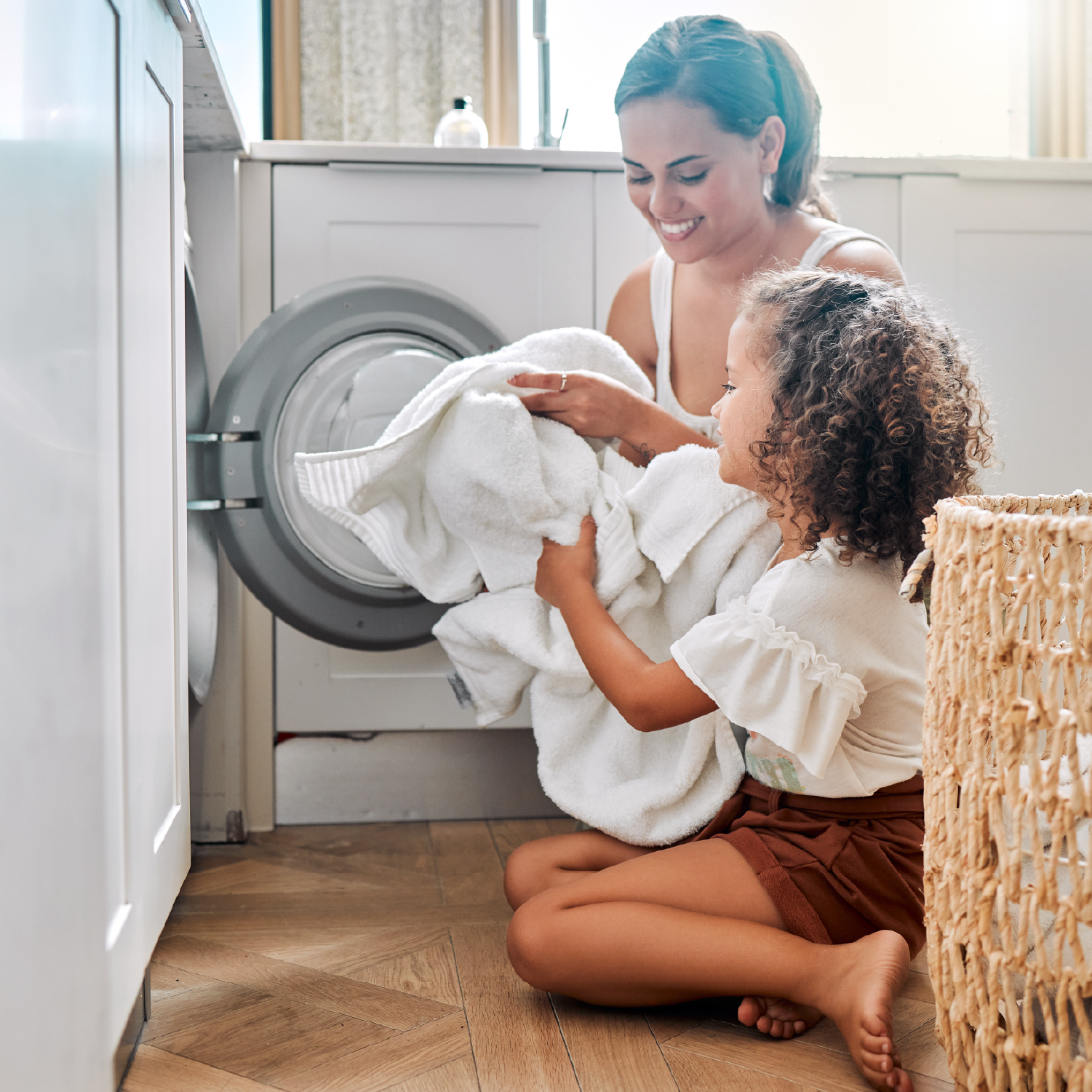 mother and daughter pulling towels out of dryer